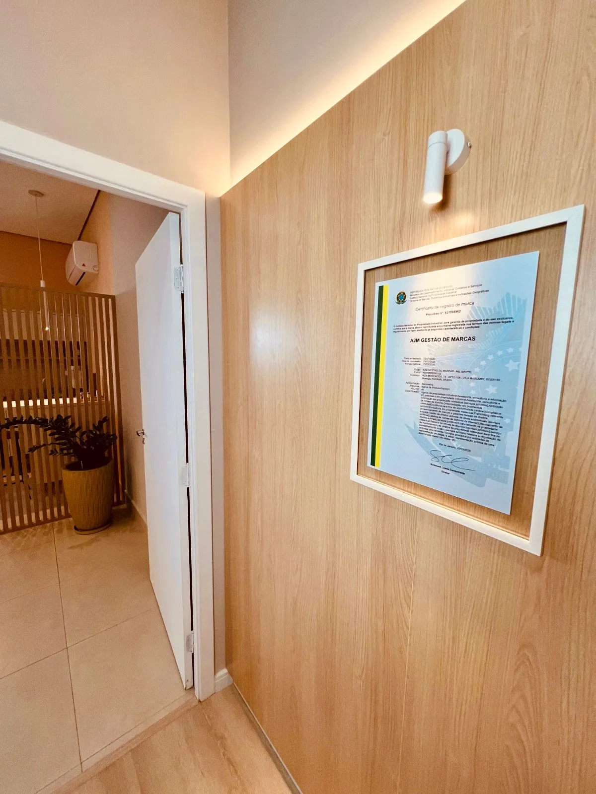 Corredor do escritório A2M com certificado de marca
